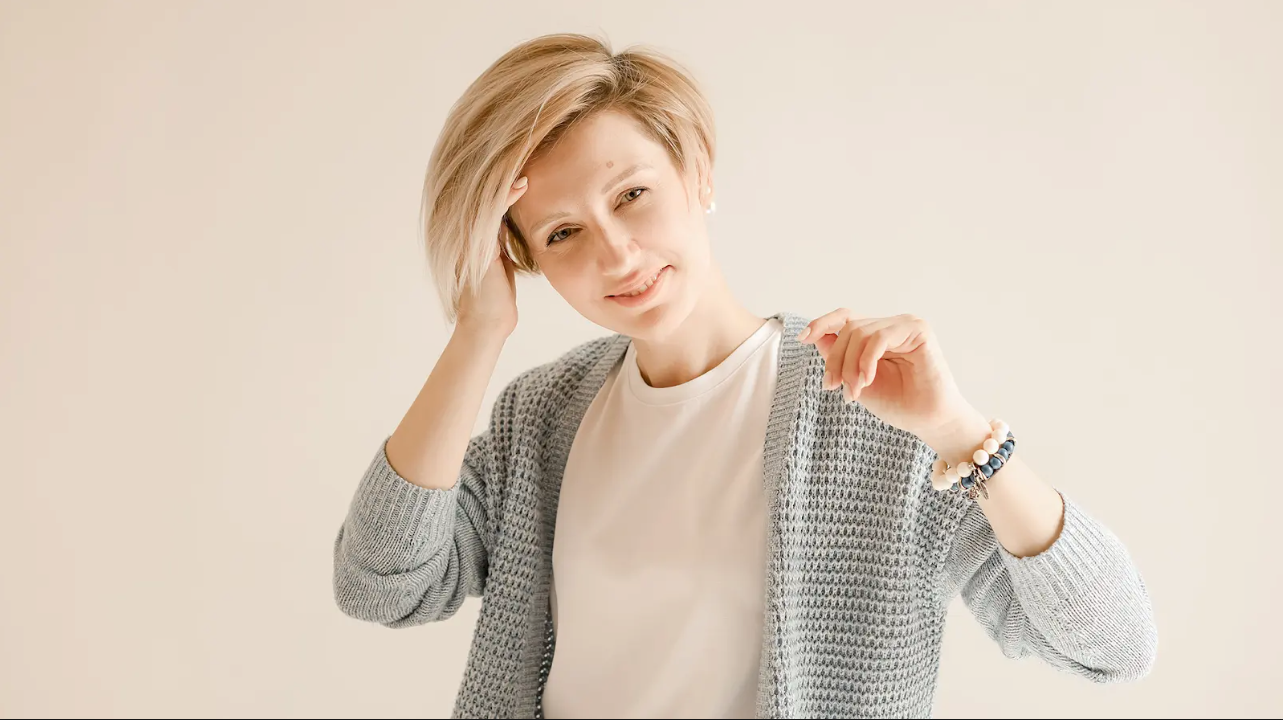 A smiling woman with a chic pixie cut hairstyle, styled in soft layers for a natural, modern look. Her confident expression and the sleek finish of the cut highlight its elegance and versatility.